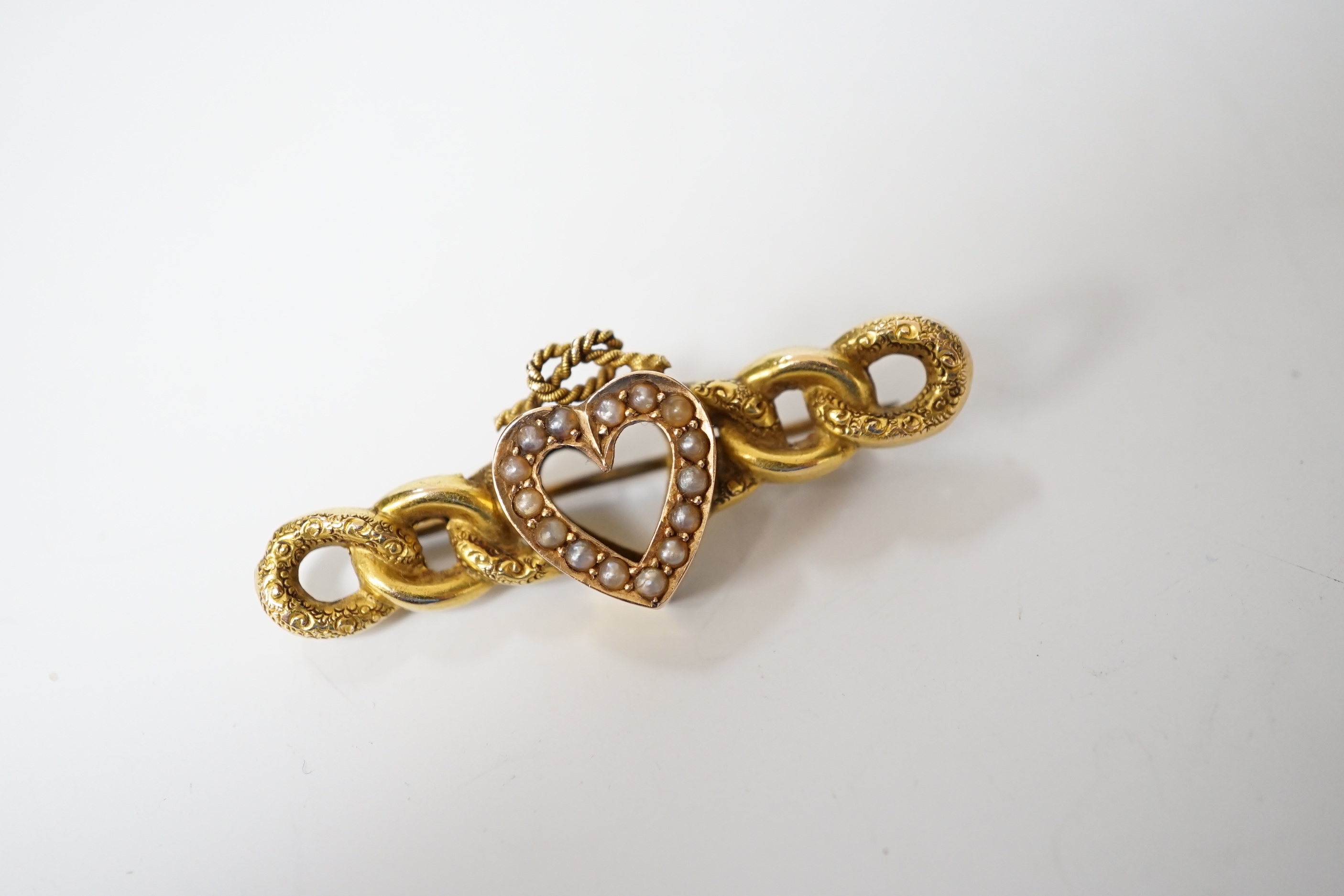 A late Victorian 15ct gold and seed pearl set bar brooch, with central heart with knot motif, 43mm, gross weight 3.8 grams.